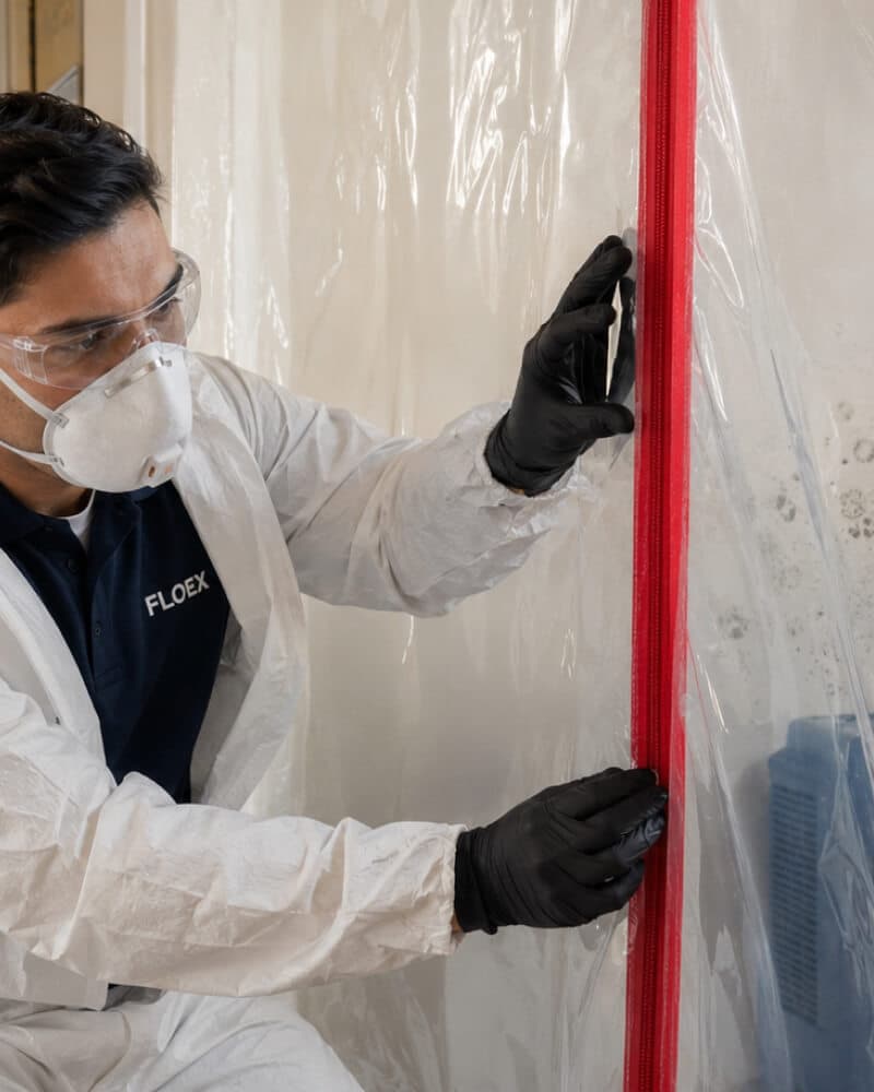 Technician sealing a containment zip door for mould treatment